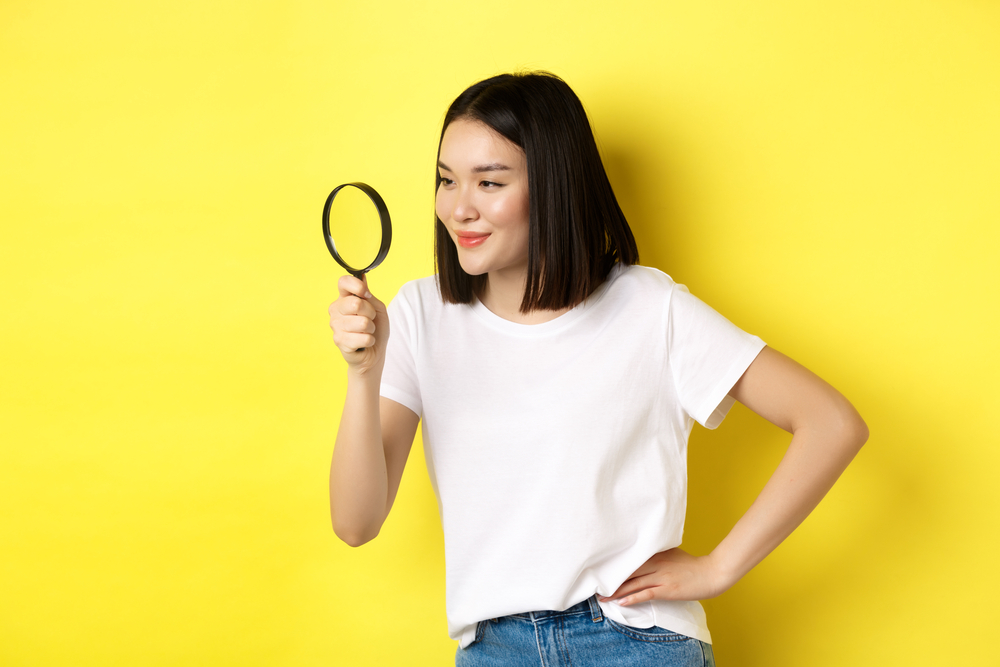 虫眼鏡をのぞいている女性